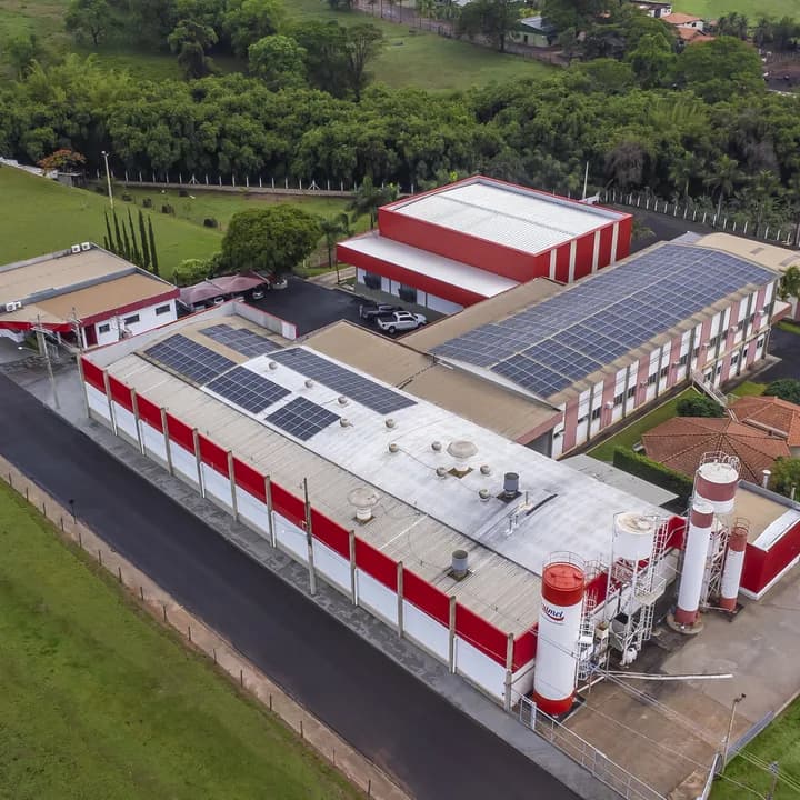 Vista aérea da fábrica da Frutmel, com os galpões de telhado vermelho e as placas solares