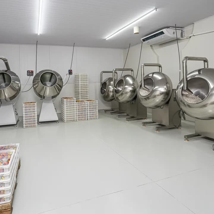 Sala das drageadeiras, com as panelas de aço inoxidável enfileiradas e as bandejas de confeitos