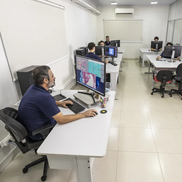 Estações de trabalho da equipe, com os monitores lado a lado