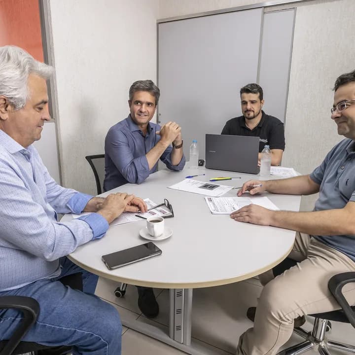 Reunião em torno da mesa, com quatro pessoas do time
