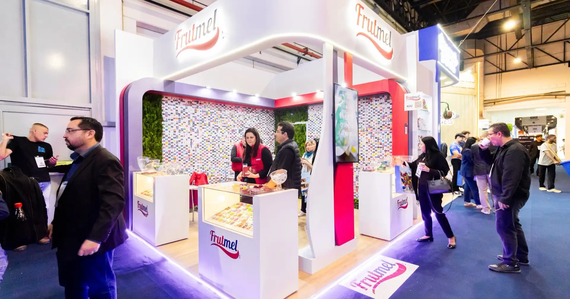 Stand da Frutmel na Equipotel, com paredes de embalagens personalizadas de clientes e balcões de amostra dos produtos