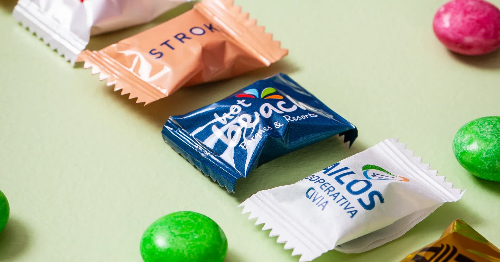 Balas mastigáveis retangulares personalizadas, enfileiradas sobre fundo verde