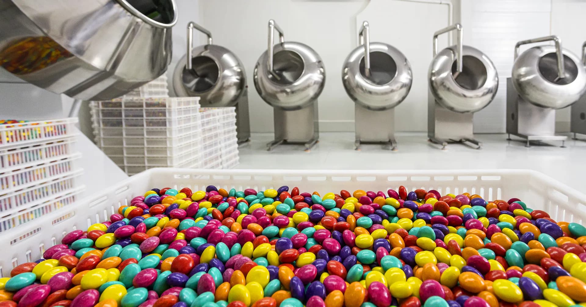 Caixa cheia de drageados coloridos na sala de drageadeiras da fábrica Frutmel